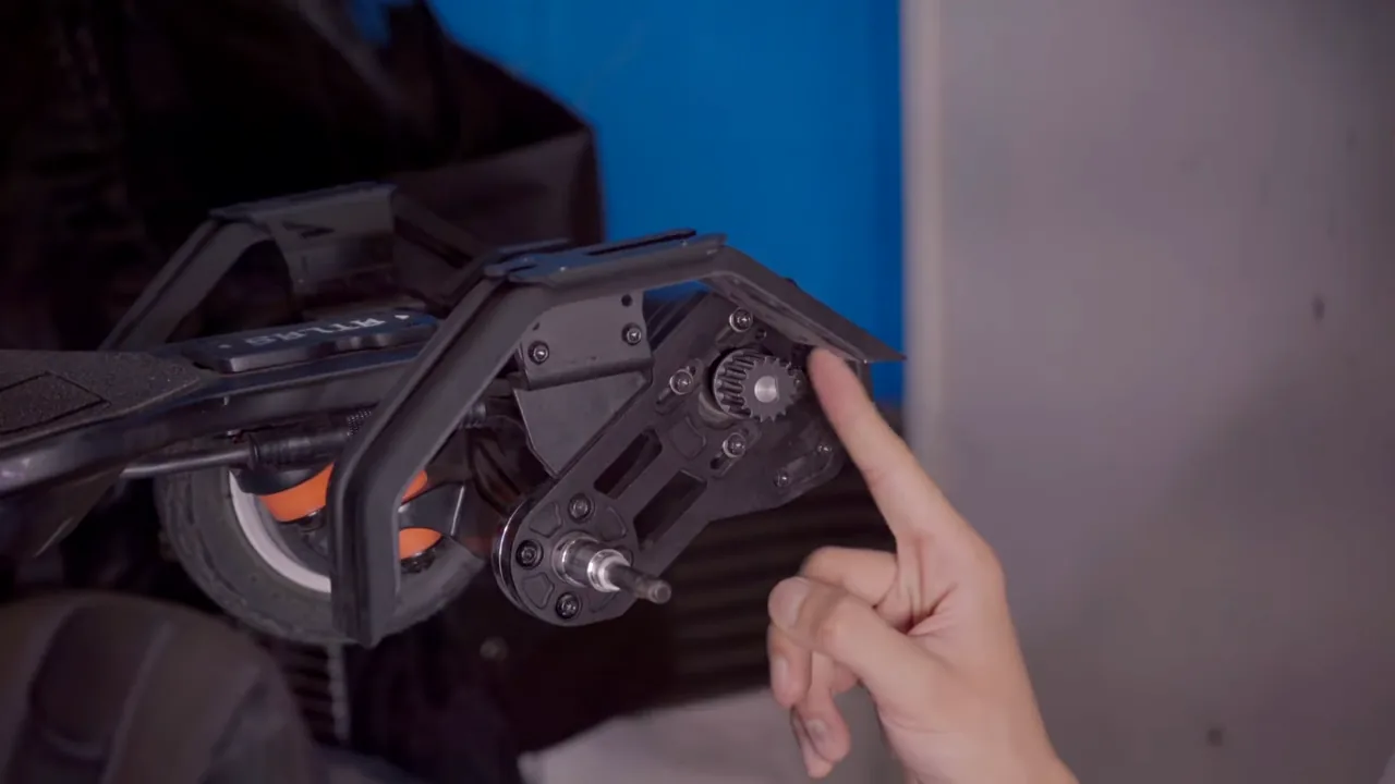 Electric skateboard drivetrain with the small metal motor pulley exposed near the belt guard
